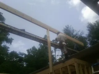 Carpenter setting a ridge beam over a new addition frame — Ice Dam Removal by Roofing Brothers in Cimarron
