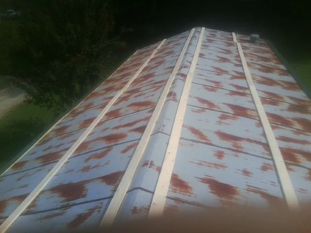 Rusted metal roof panels with new wood purlins before replacement — Storm Damage Roof Repair in Cimarron by Roofing Brothers