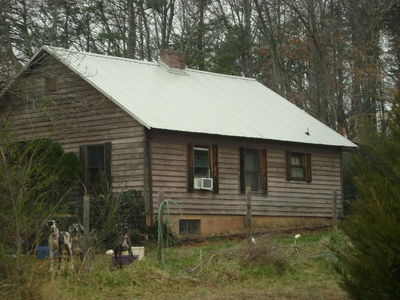 White metal roof on an old wood sided farmhouse, from a Asphalt Shingle Roof Repair job in Cimarron